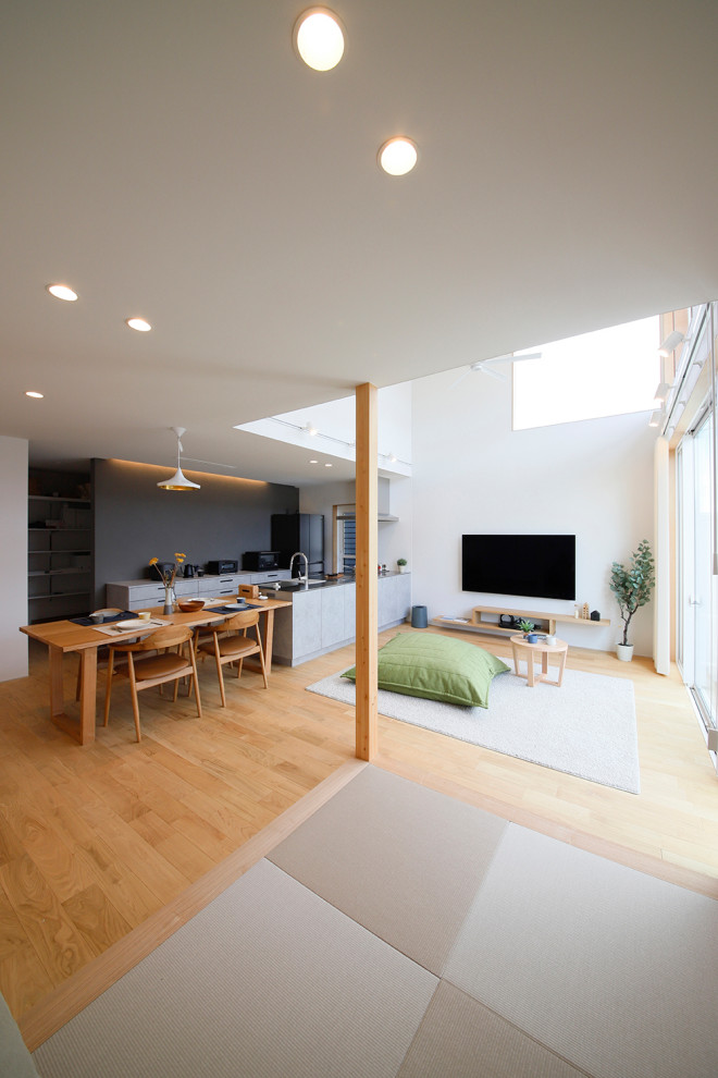 Idee per un soggiorno minimalista aperto con pareti bianche, pavimento in legno massello medio, nessun camino, TV a parete e soffitto in legno