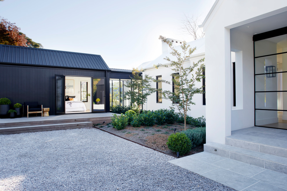 This is an example of a mid-sized modern one-storey concrete black house exterior in Other with a gable roof and a metal roof.