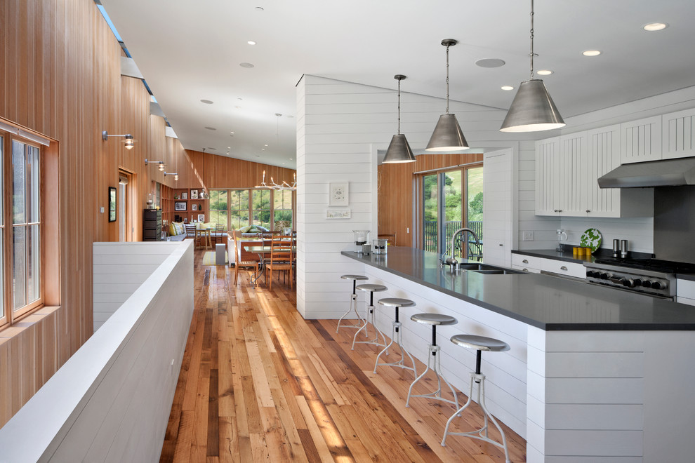 Contemporary kitchen in San Francisco with a double-bowl sink, grey splashback, stainless steel appliances, medium hardwood floors and with island.