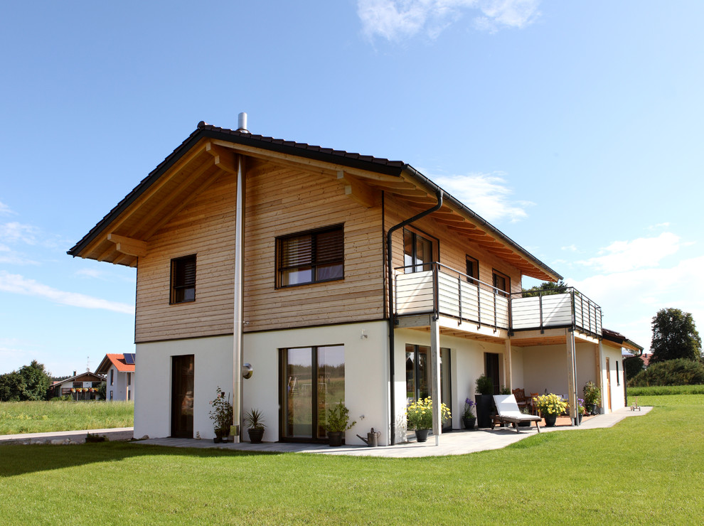 Inspiration for a large country two-storey house exterior in Munich with mixed siding and a gable roof.