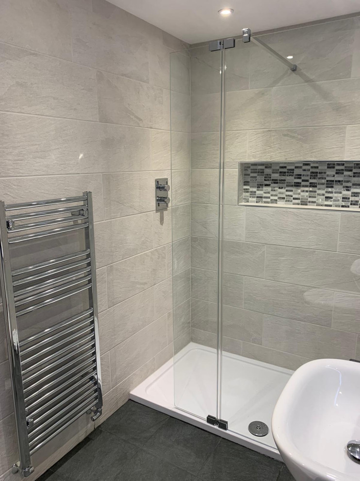 Идея дизайна: главная, серо-белая ванная комната среднего размера в стиле модернизм с плоскими фасадами, белыми фасадами, душем без бортиков, унитазом-моноблоком, серой плиткой, керамической плиткой, серыми стенами, полом из керамогранита, врезной раковиной, столешницей из искусственного камня, серым полом, открытым душем, серой столешницей, акцентной стеной, тумбой под одну раковину, встроенной тумбой и кирпичными стенами