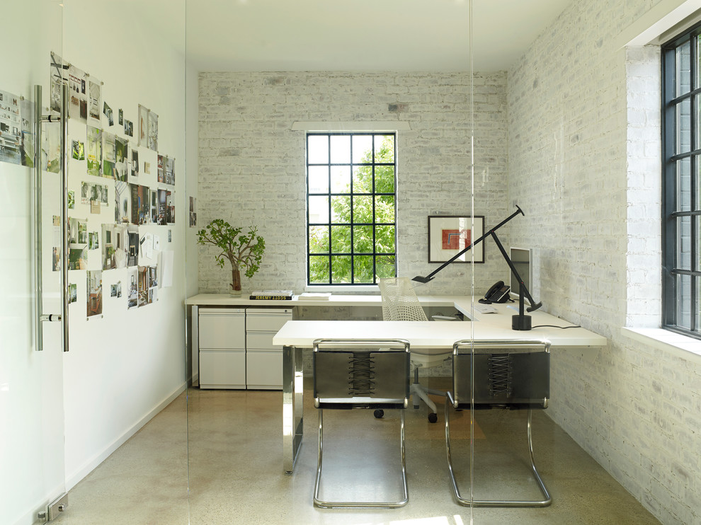Inspiration for a large contemporary home studio in Houston with white walls, concrete floors, a freestanding desk and beige floor.