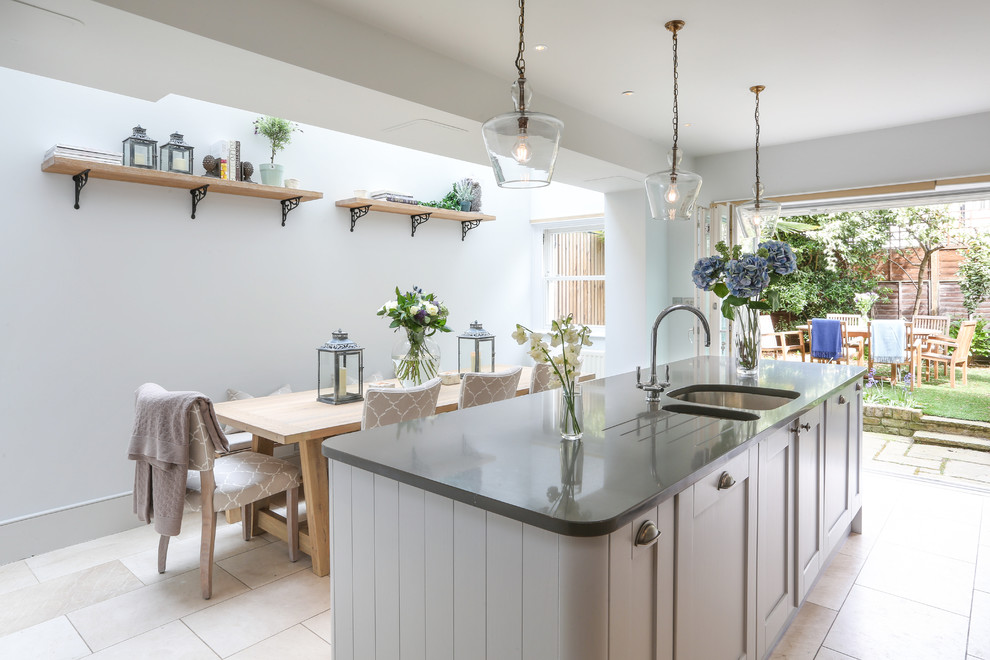 Photo of a mid-sized transitional eat-in kitchen in London with an undermount sink, shaker cabinets, grey cabinets, with island and beige floor.