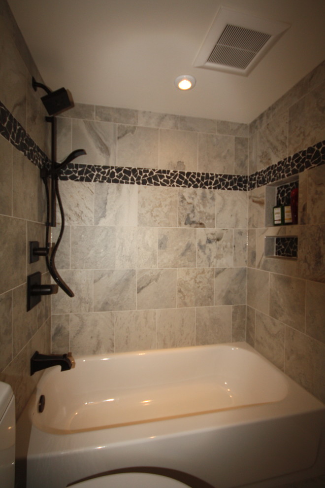 Photo of a small transitional 3/4 bathroom in DC Metro with raised-panel cabinets, white cabinets, an alcove tub, a shower/bathtub combo, a two-piece toilet, gray tile, stone tile, blue walls, travertine floors, an undermount sink and granite benchtops.