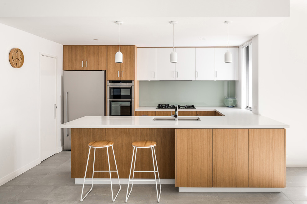 Design ideas for a modern u-shaped kitchen pantry in Perth with an undermount sink, light wood cabinets, quartz benchtops, grey splashback, glass sheet splashback, stainless steel appliances, ceramic floors, grey floor and white benchtop.
