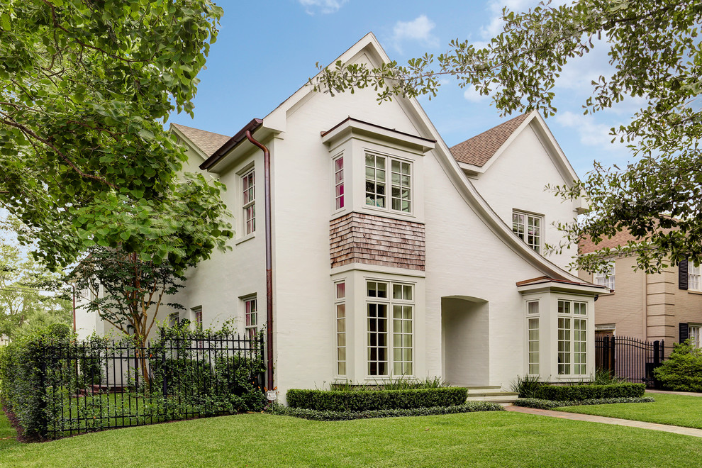 Photo of a large traditional two-storey brick beige exterior in Houston with a flat roof.