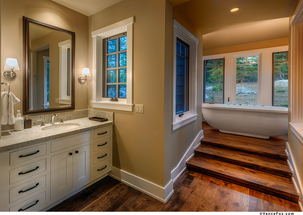 Inspiration for a country bathroom in Sacramento with a drop-in sink, medium wood cabinets, wood benchtops, a freestanding tub, a one-piece toilet and yellow walls.