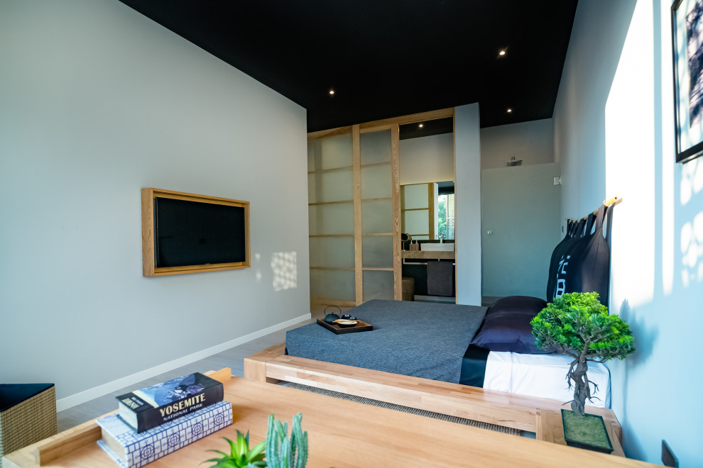 Mid-sized asian loft-style bedroom with grey walls and ceramic floors.