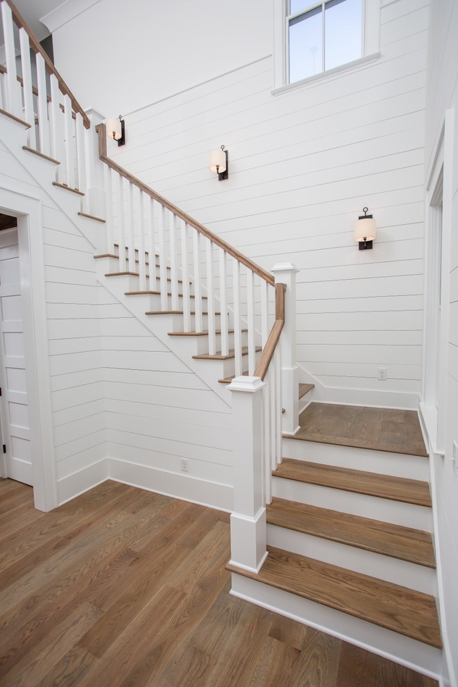 This is an example of a large country wood u-shaped staircase in Jacksonville with wood risers and wood railing.