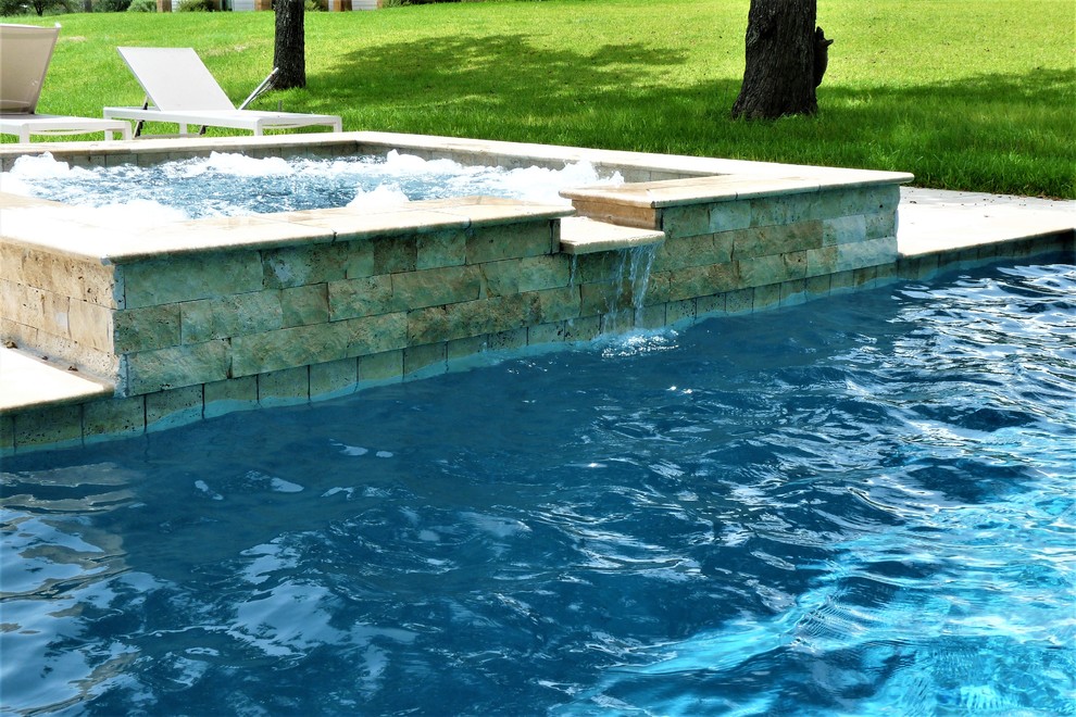 Large trendy backyard stone and rectangular natural hot tub photo in Houston