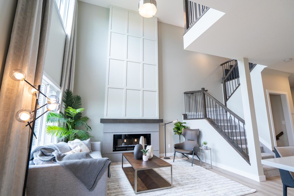 Mid-sized transitional open concept living room in Edmonton with grey walls, light hardwood floors, a ribbon fireplace, a tile fireplace surround, no tv and beige floor.