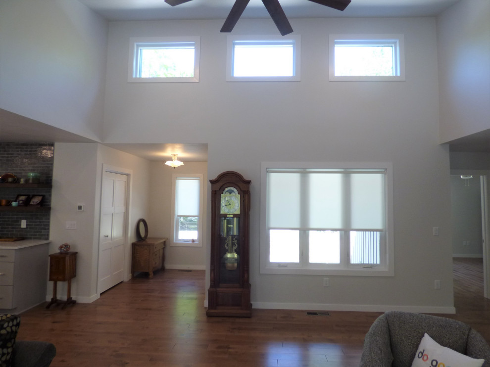 Contemporary entryway in Other with white walls, medium hardwood floors, brown floor and vaulted.