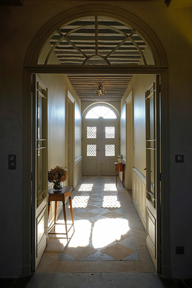 Expansive traditional hallway in Dijon with beige walls and limestone floors.