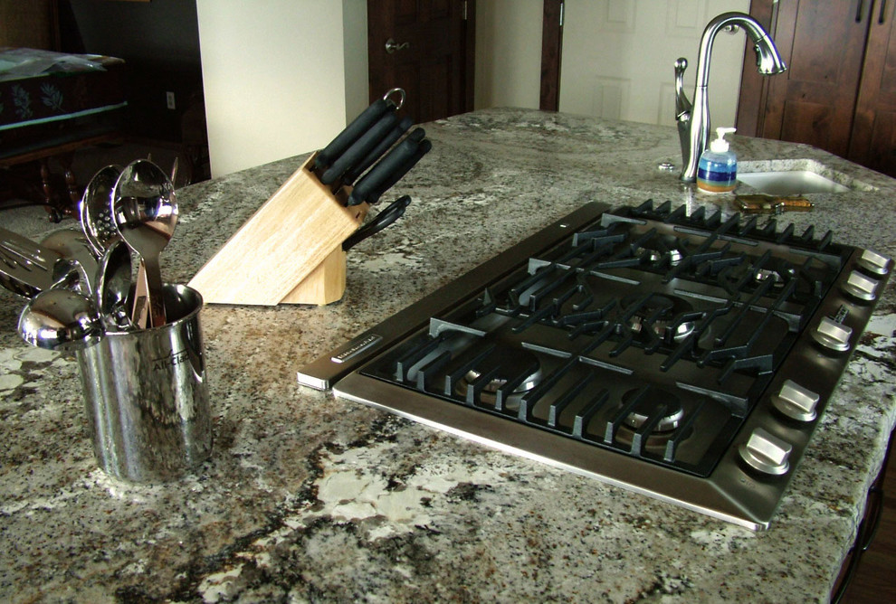 Example of a large mountain style u-shaped medium tone wood floor home design design in Denver with a farmhouse sink, flat-panel cabinets, dark wood cabinets, granite countertops, gray backsplash, stainless steel appliances and an island