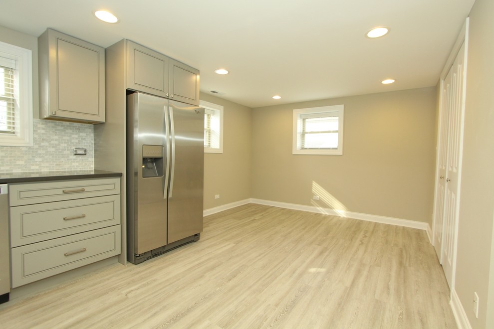 Inspiration for a small transitional l-shaped porcelain tile and gray floor kitchen remodel in Chicago with an undermount sink, beaded inset cabinets, gray cabinets, quartz countertops, white backsplash, mosaic tile backsplash, stainless steel appliances, no island and gray countertops