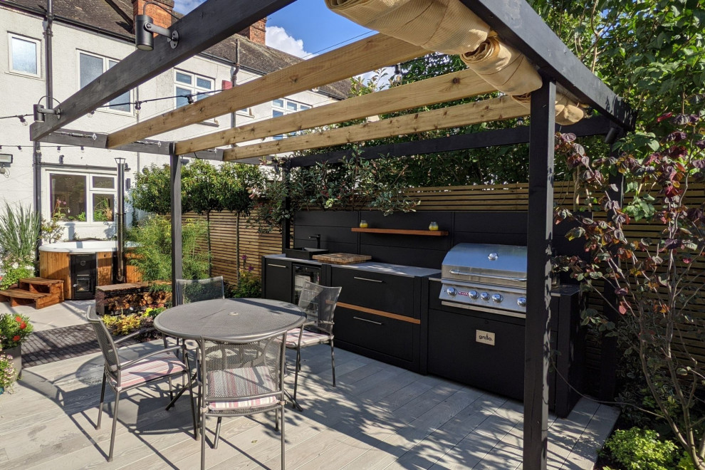 Réalisation d'une terrasse arrière design avec une cuisine d'été et une pergola.