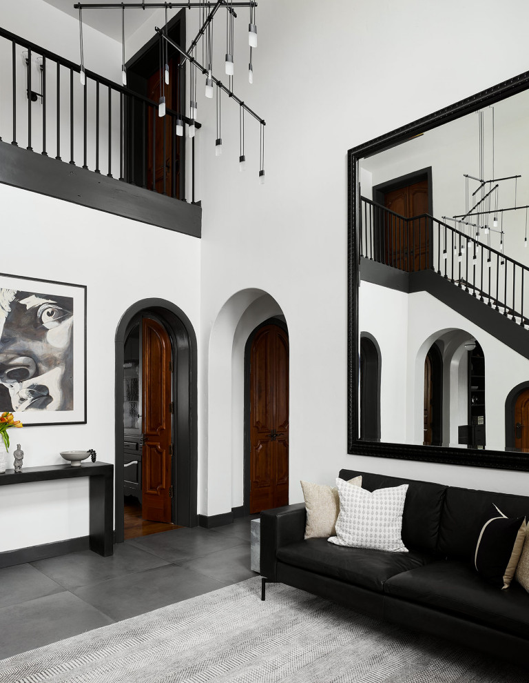This is an example of a large contemporary foyer in Chicago with white walls, porcelain flooring, a single front door, a medium wood front door, grey floors and a vaulted ceiling.