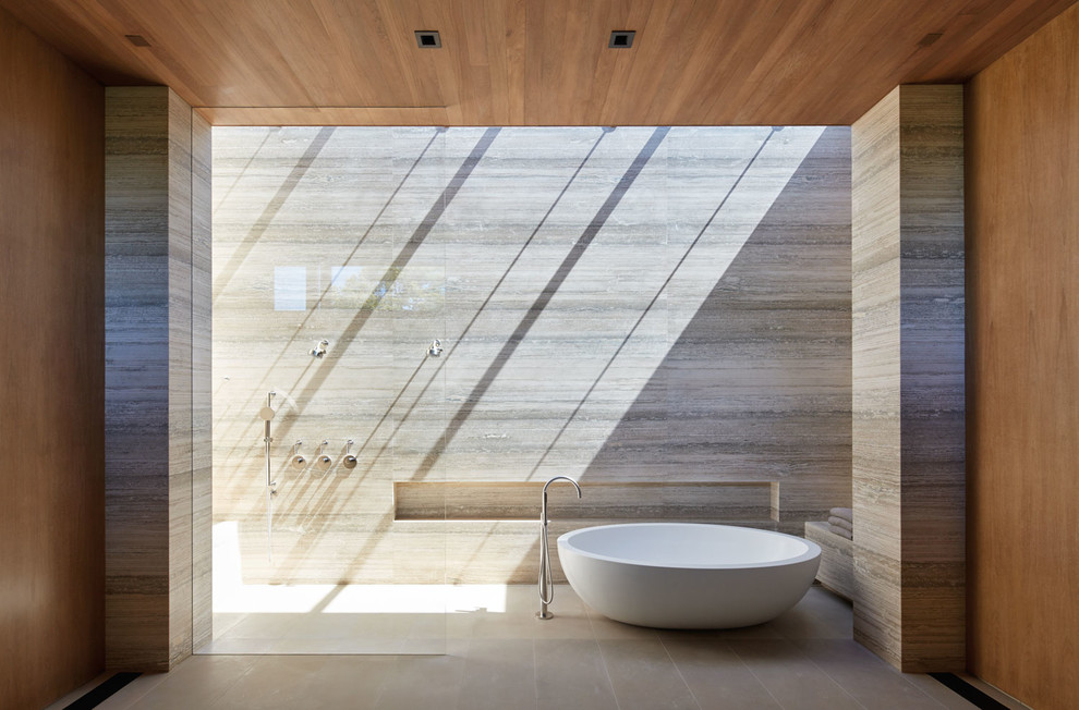 This is an example of a large modern master bathroom in Other with a freestanding tub, travertine, limestone floors, beige floor, an open shower, a curbless shower, gray tile and grey walls.