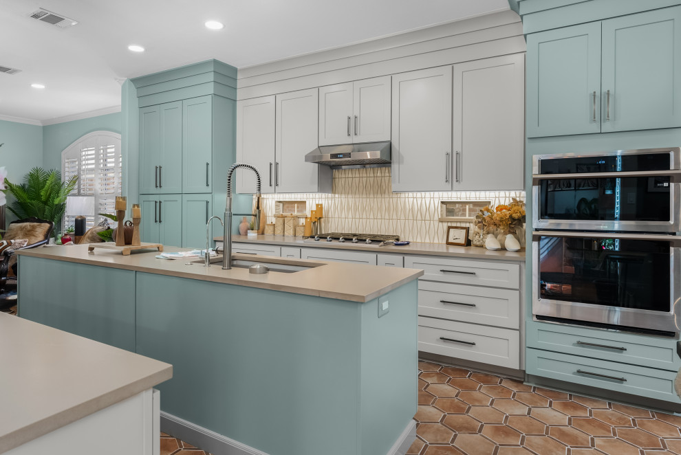 Example of a mid-sized transitional ceramic tile kitchen design in Austin with an undermount sink, shaker cabinets, quartz countertops, ceramic backsplash, stainless steel appliances and an island