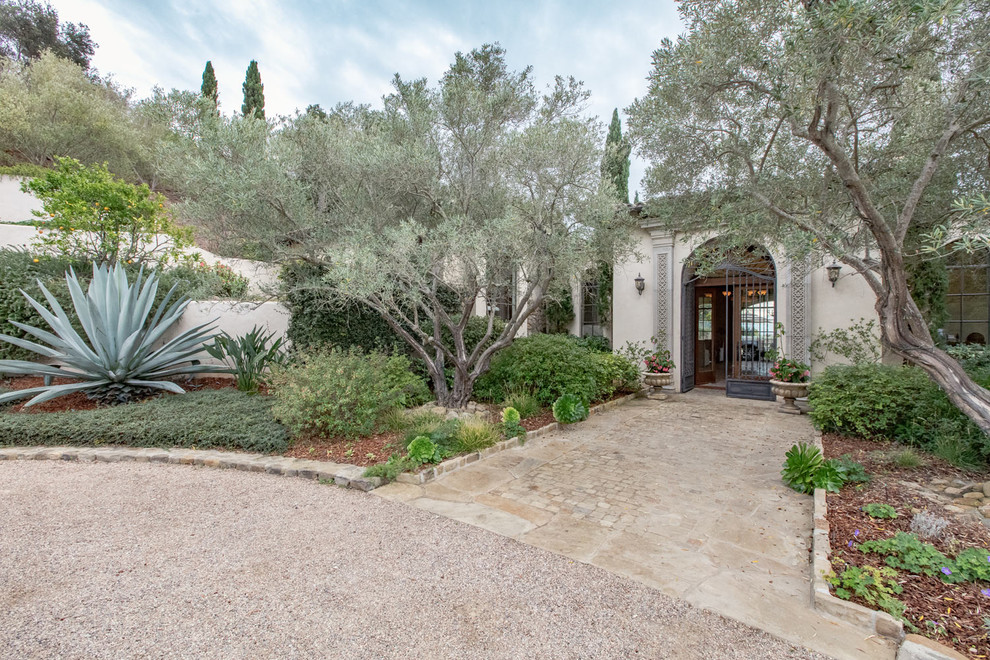 Large tuscan limestone floor front door photo in Austin with beige walls and a metal front door