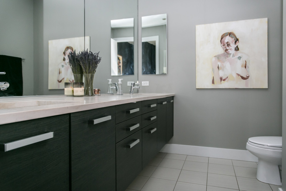 Mid-sized contemporary 3/4 wet room bathroom in Chicago with flat-panel cabinets, black cabinets, a one-piece toilet, white tile, ceramic tile, beige walls, ceramic floors, an undermount sink, engineered quartz benchtops, white floor and a hinged shower door.