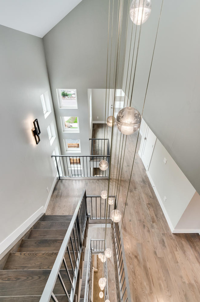 Mid-sized modern wood floating staircase in Denver with open risers and metal railing.