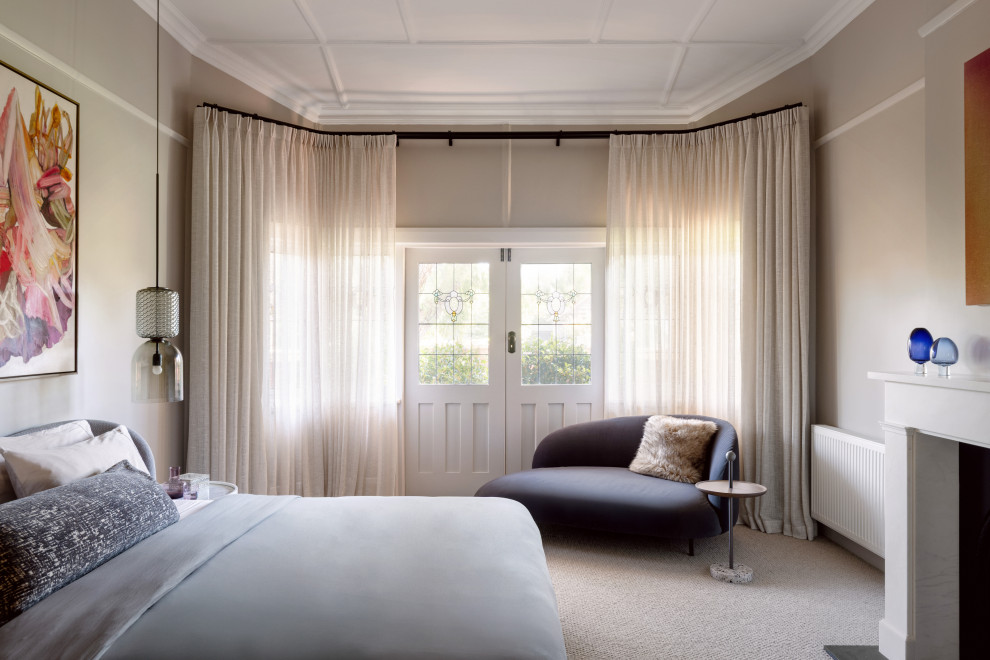 Transitional bedroom in Melbourne with carpet, a standard fireplace and beige floor.