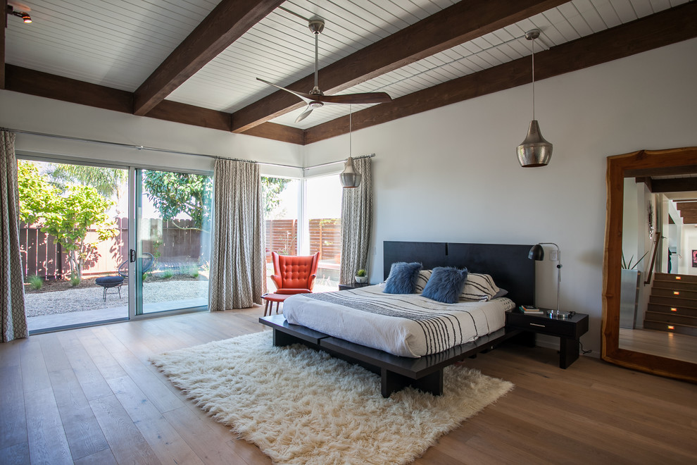 Ispirazione per una camera matrimoniale minimalista con pareti bianche, pavimento in legno massello medio e pavimento beige