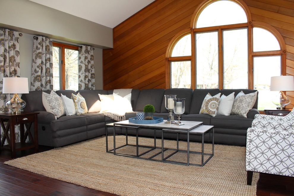 This is an example of a transitional family room in New York with grey walls and dark hardwood floors.