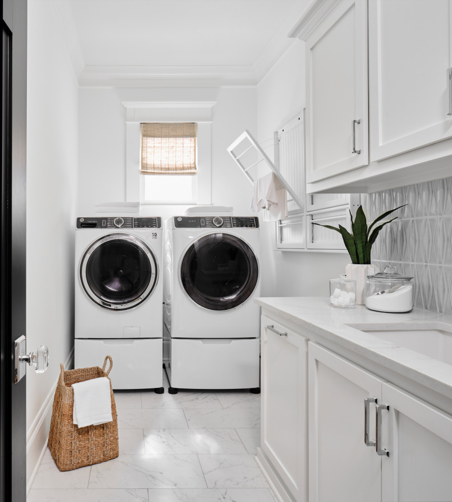Design ideas for a small beach style l-shaped dedicated laundry room in Houston with an undermount sink, shaker cabinets, white cabinets, quartz benchtops, blue splashback, ceramic splashback, white walls, porcelain floors, a side-by-side washer and dryer, grey floor and white benchtop.