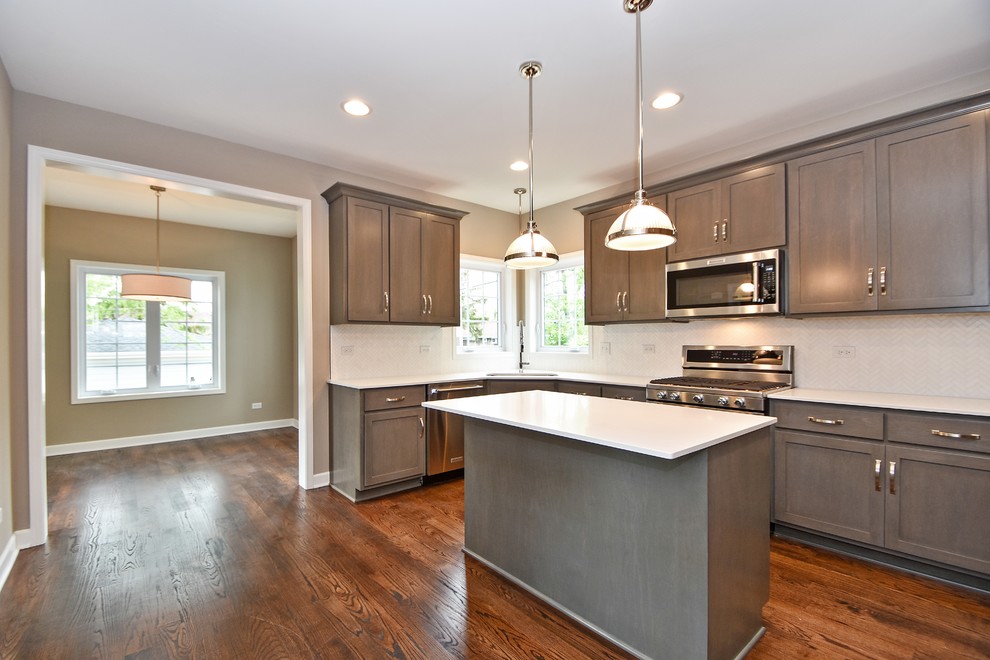 Example of a mid-sized transitional u-shaped dark wood floor eat-in kitchen design in Chicago with an undermount sink, recessed-panel cabinets, dark wood cabinets, white backsplash, stainless steel appliances and an island