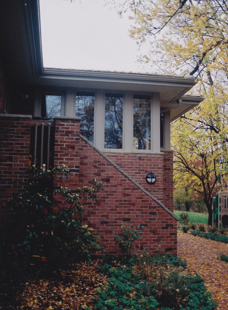 Photo of a mid-sized midcentury one-storey brick red exterior in Other.