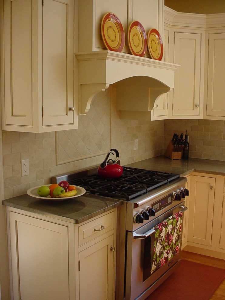 Mid-sized contemporary l-shaped eat-in kitchen in Boston with an undermount sink, shaker cabinets, white cabinets, granite benchtops, beige splashback, ceramic splashback, stainless steel appliances, light hardwood floors and with island.