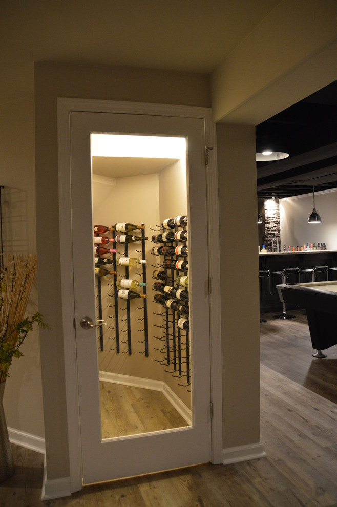 Photo of a small modern wine cellar in Detroit with vinyl floors, storage racks and brown floor.