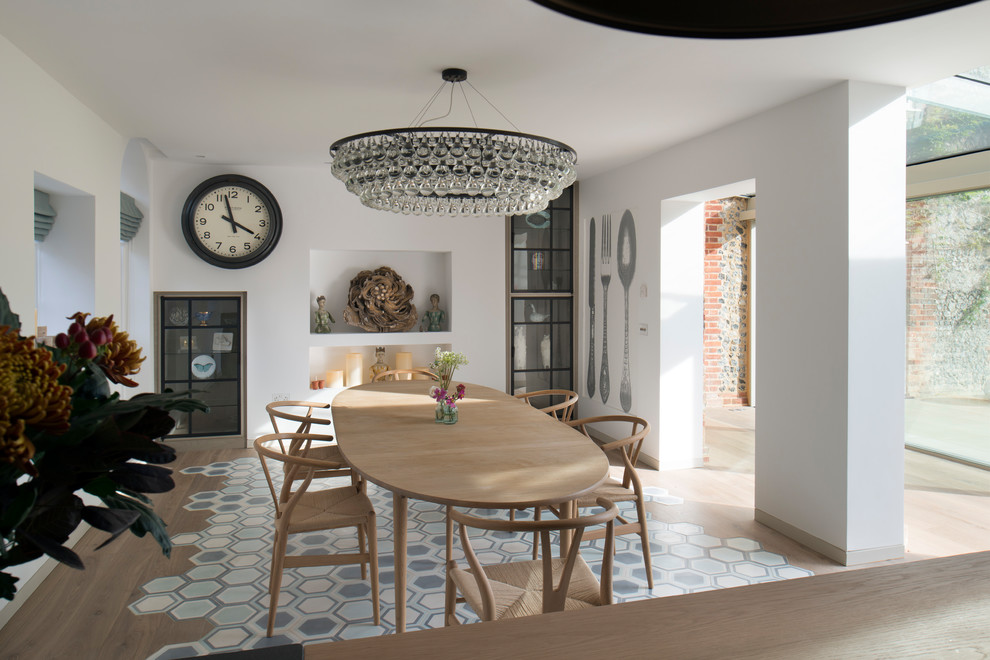 Design ideas for a mid-sized eclectic dining room in Oxfordshire with white walls, no fireplace and multi-coloured floor.