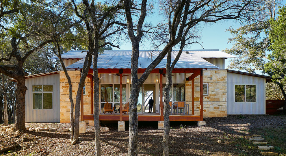 Inspiration for a small contemporary one-storey exterior in Austin with stone veneer and a gable roof.