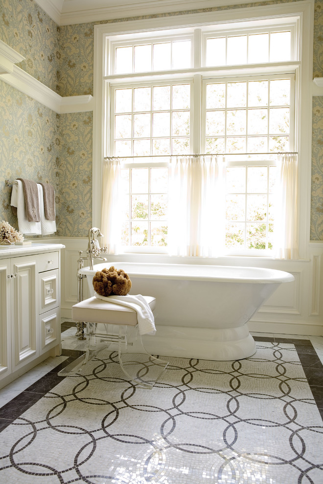 Inspiration for a large traditional master bathroom in New York with a freestanding tub, multi-coloured walls, white cabinets, marble benchtops, multi-coloured tile, mosaic tile, mosaic tile floors and raised-panel cabinets.