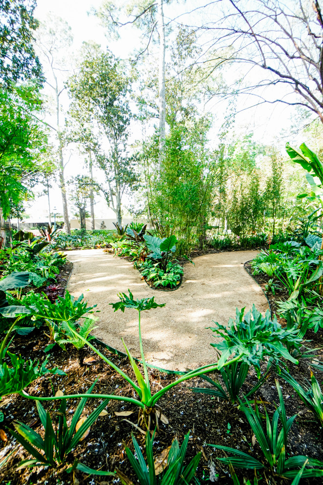 Mid-sized tropical backyard partial sun formal garden in Houston with a garden path and brick pavers for spring.