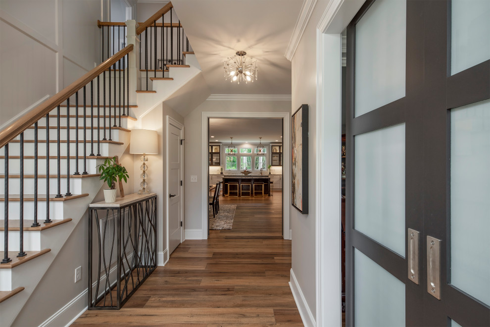 This is an example of a large transitional entry hall in Other with grey walls, medium hardwood floors and brown floor.
