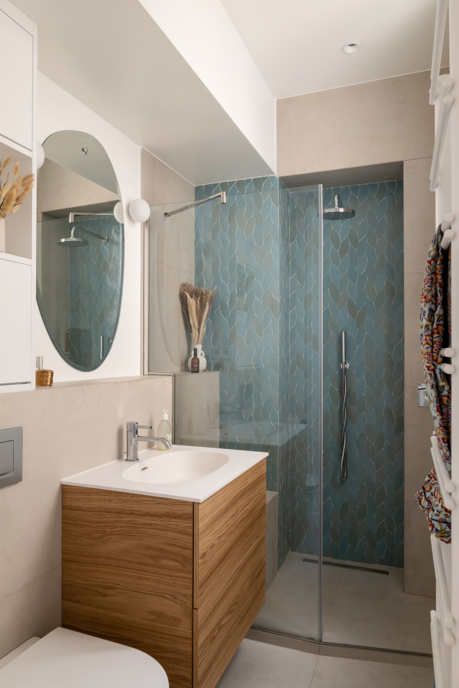 This is an example of a small contemporary shower room bathroom in Paris with light wood cabinets, a walk-in shower, blue tiles, ceramic flooring, a wall-mounted sink, solid surface worktops, a hinged door and a single sink.