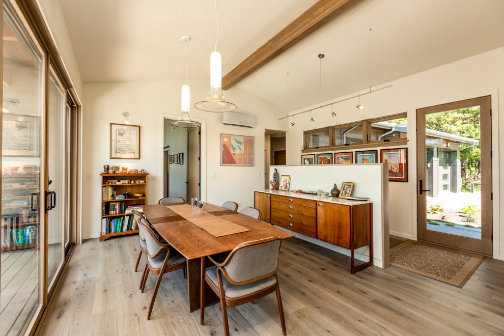 Design ideas for a mid-sized midcentury dining room in Seattle with white walls, medium hardwood floors, brown floor, exposed beam and vaulted.