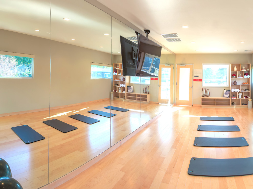 Photo of a large contemporary home yoga studio in San Francisco with beige walls and light hardwood floors.