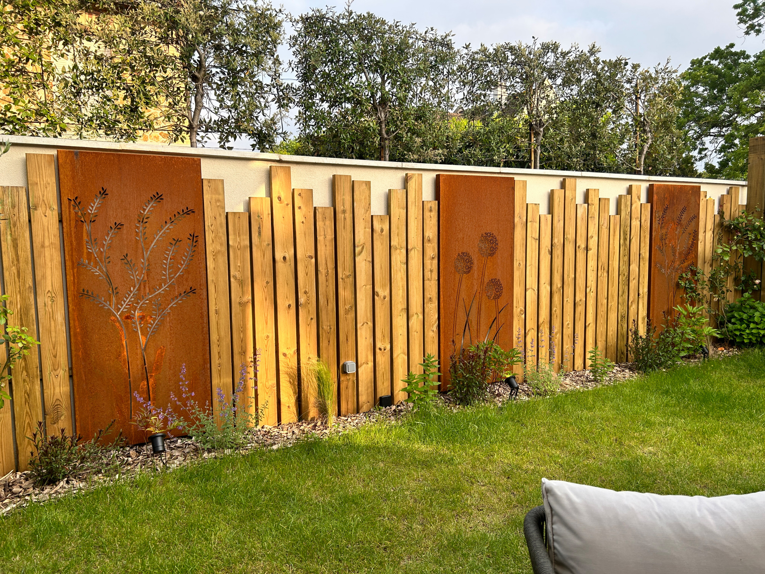 Aménagement du jardin avec des palissades en bois et des arbres palissés.