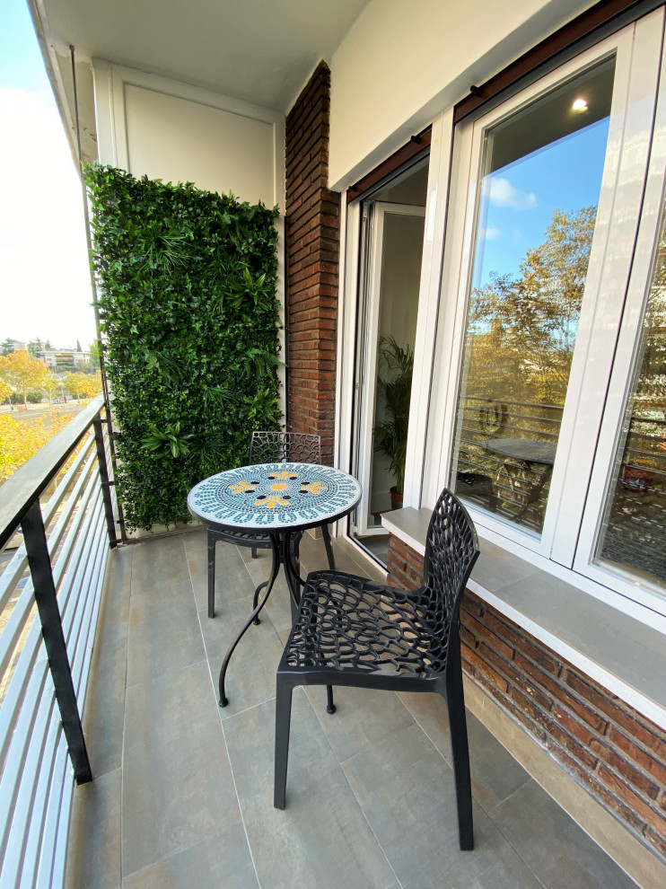 Cette photo montre un petit balcon tendance avec un jardin vertical, aucune couverture et un garde-corps en métal.