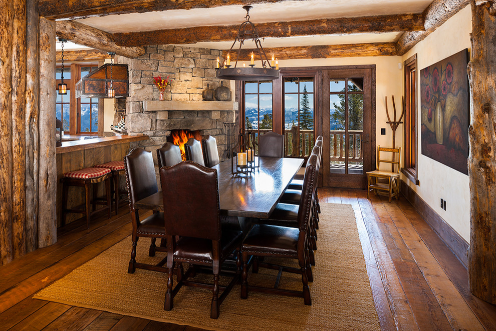 This is an example of a large country dining room in Other with a corner fireplace and a stone fireplace surround.