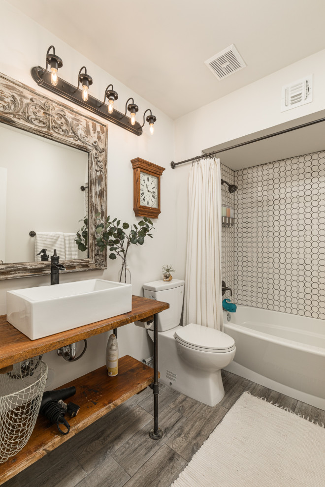 Mediterranean bathroom in Phoenix with an alcove tub, a shower/bathtub combo, a two-piece toilet, white tile, mosaic tile, white walls, a vessel sink, wood benchtops, grey floor, brown benchtops and a single vanity.