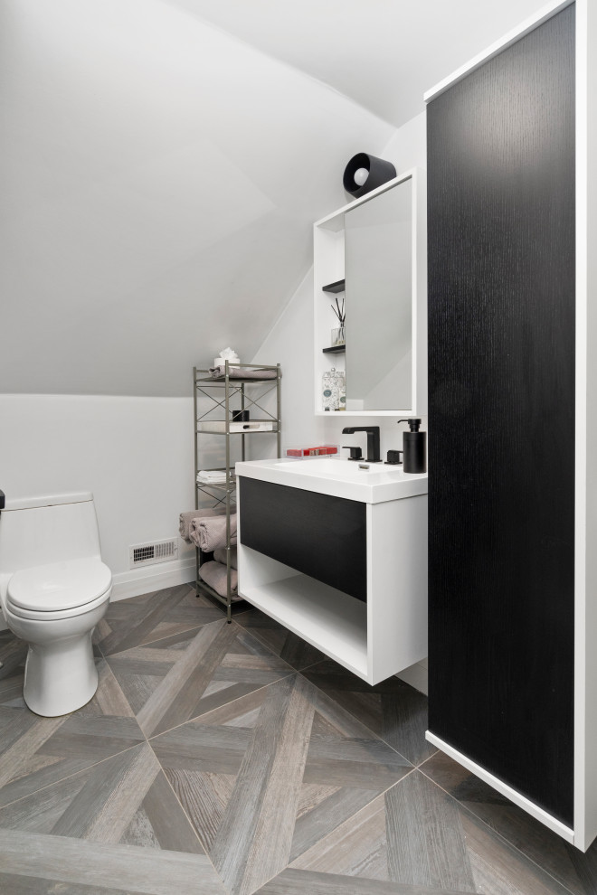 Modern bathroom with flat-panel cabinets, white cabinets, a console sink, grey floor, white benchtops, black tile, porcelain tile, white walls, porcelain floors, laminate benchtops, a hinged shower door and a single vanity.