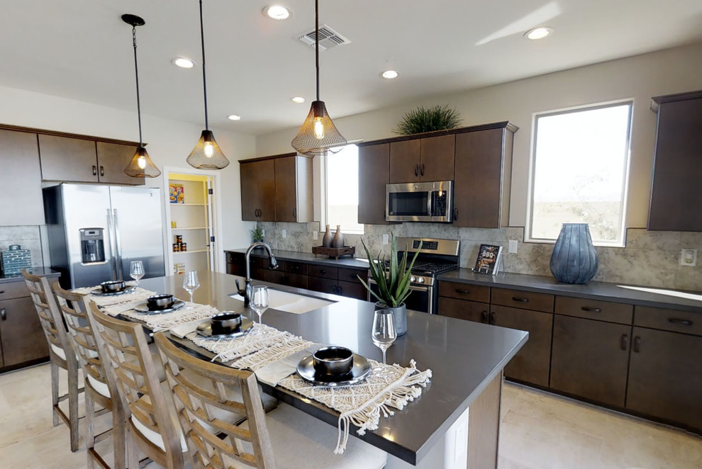 Mid-sized transitional galley open concept kitchen photo in Milwaukee with a double-bowl sink, flat-panel cabinets, dark wood cabinets, white backsplash, stainless steel appliances and an island