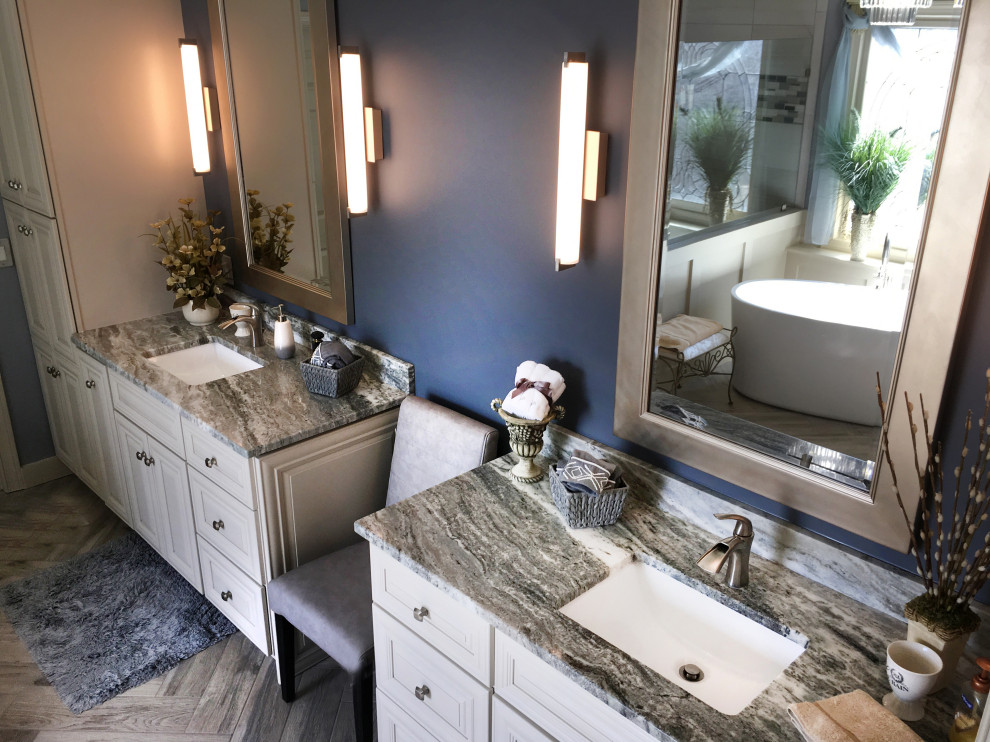 Example of a large transitional master beige tile and ceramic tile porcelain tile and gray floor freestanding bathtub design in Atlanta with recessed-panel cabinets, yellow cabinets, a two-piece toilet, blue walls, an undermount sink, granite countertops, a hinged shower door and multicolored countertops