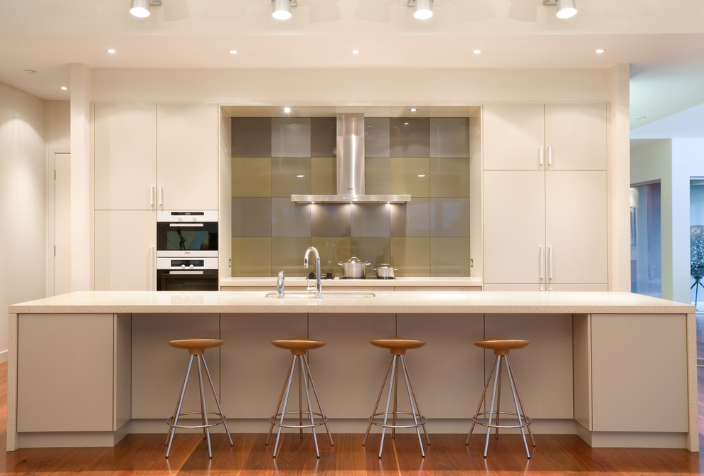 Inspiration for a large contemporary galley open plan kitchen in Sydney with an undermount sink, flat-panel cabinets, grey cabinets, quartz benchtops, multi-coloured splashback, glass tile splashback, stainless steel appliances, medium hardwood floors and with island.